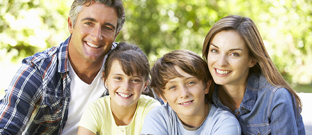 Smiling family sitting outside